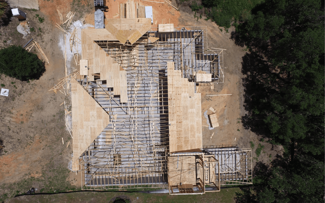 Aerial view of home construction framing and roofing stages in Clermont, FL, managed by Bridgethorn, a local general contractor.