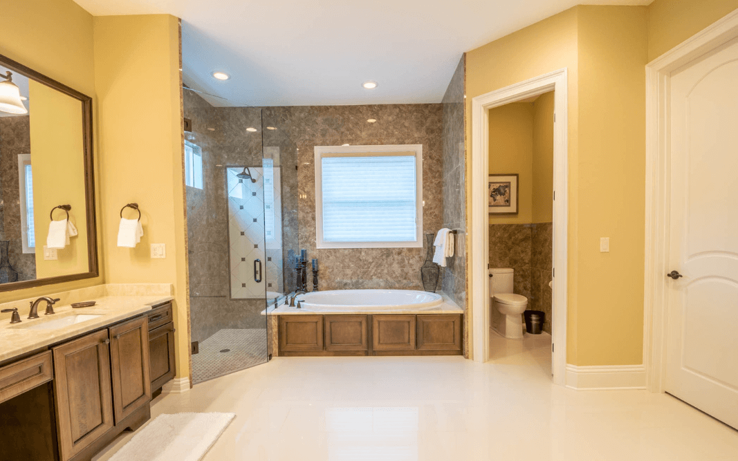 Master bathroom with soaking tub, large glass shower, and dual vanity in a high-end custom home in Clermont, FL.