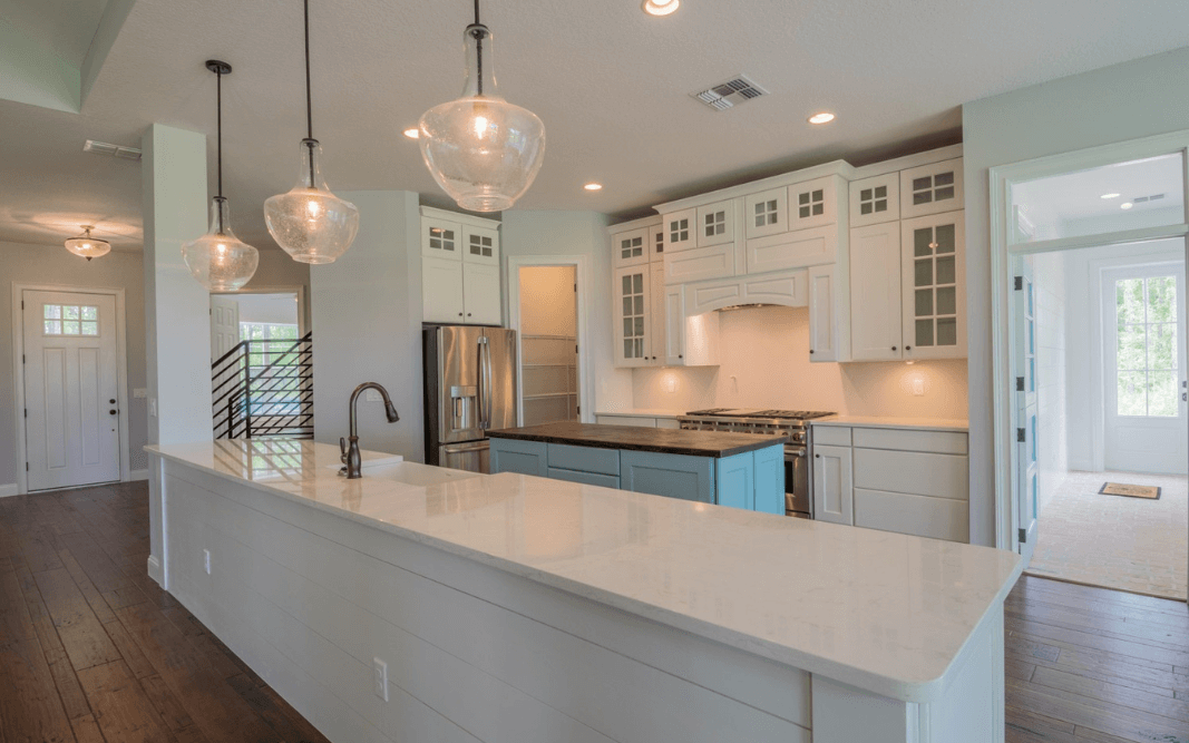 Modern custom kitchen with a large island, high-end appliances, and pendant lighting in a Clermont, FL home by Bridgethorn Construction.