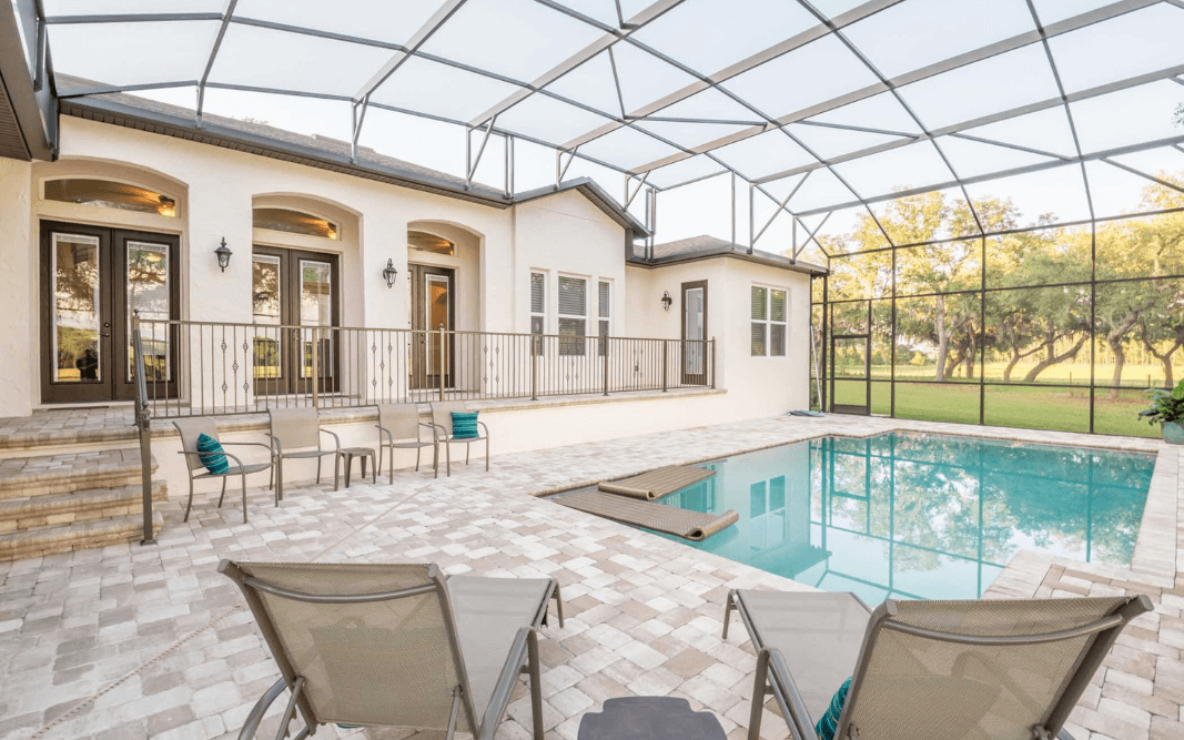 Screened-in pool area and outdoor living space of a custom-built luxury home in Clermont, FL, by Bridgethorn Construction.