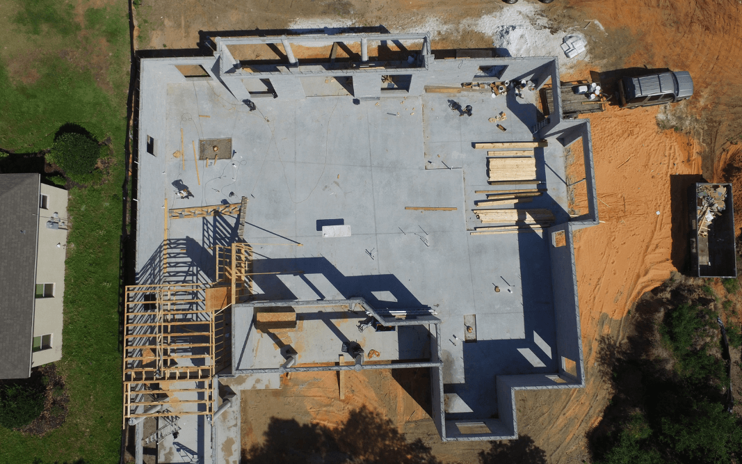 Aerial view of commercial building construction site in Clermont, FL, showing foundation work and framing in progress, part of Bridgethorn Construction’s detailed building process.