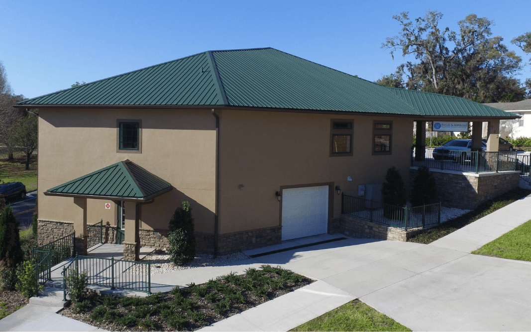 Newly completed commercial office building with green metal roofing in Clermont, FL, constructed by Bridgethorn Construction, specializing in commercial spaces.