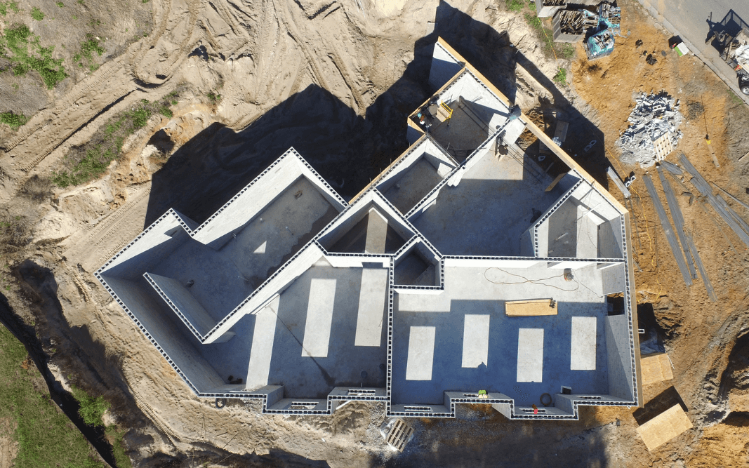 Aerial view of an office building foundation under construction in Clermont, FL, showcasing commercial construction and renovation services by Bridgethorn Construction.